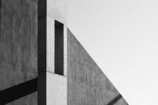 Minimalistisk betongarkitektur med person i stort negativt rom