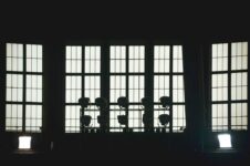 Minimalistisk scene med scenelys foran høye, opplyste vinduer